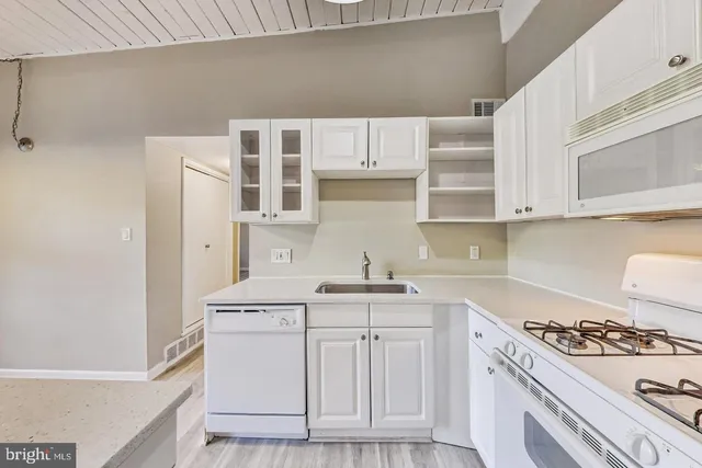 a kitchen with cabinets appliances and a sink