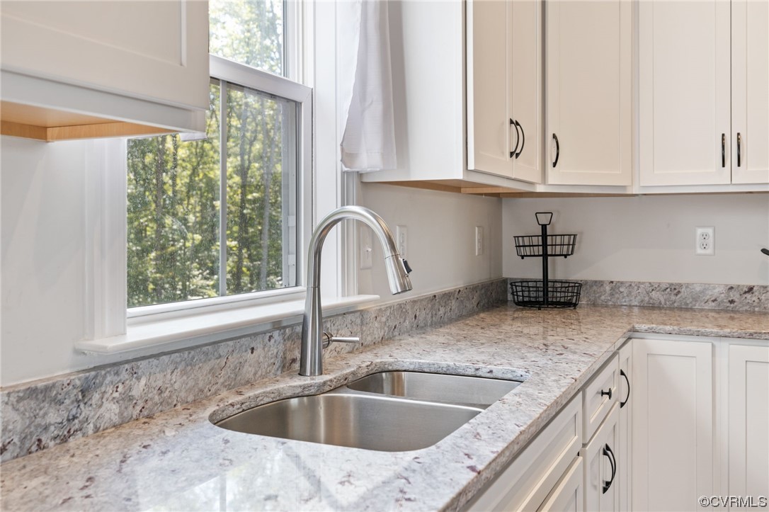 922 Kennon Road Mineral, VA 23117 - Photo 18 of 36 a kitchen with granite countertop a sink and white cabinets next to a window