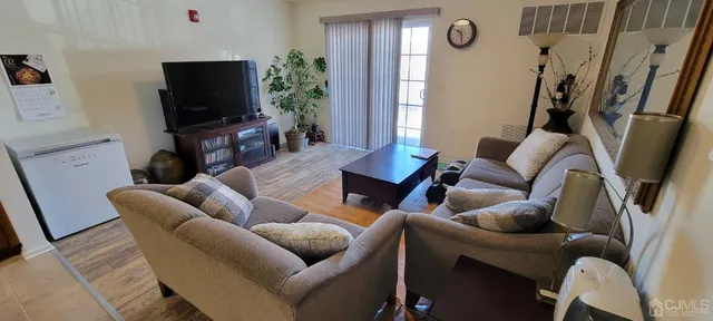 a front view of a building with lots of flowers and trees