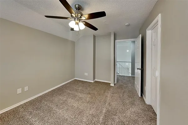 an empty room with fan and entrance