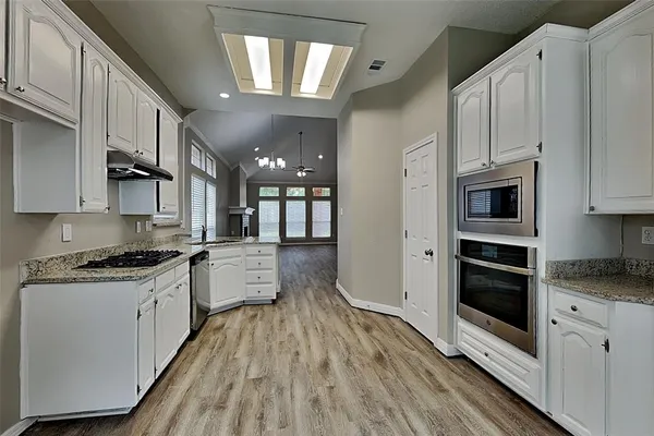 a large kitchen with stainless steel appliances granite countertop a stove and a refrigerator
