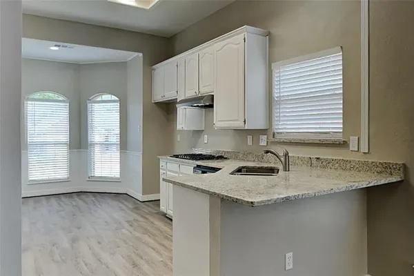 a kitchen with a stove a sink a refrigerator and window