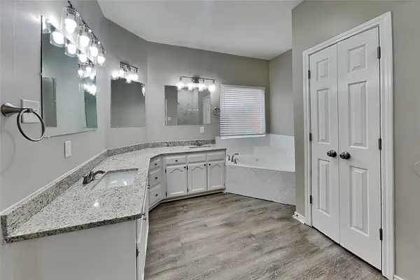 a bathroom with a sink double vanity granite and a mirror