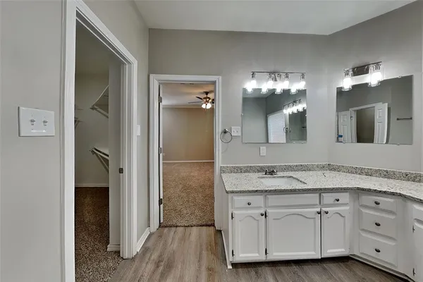 a spacious bathroom with a granite countertop sink vanity and mirror