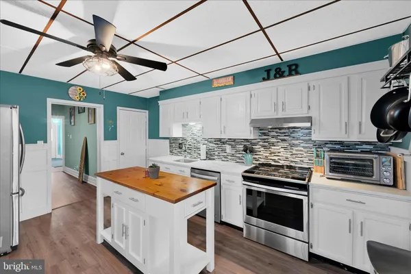 a kitchen with stainless steel appliances granite countertop a sink a stove and a refrigerator