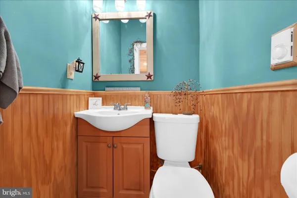 a bathroom with a toilet a sink and mirror