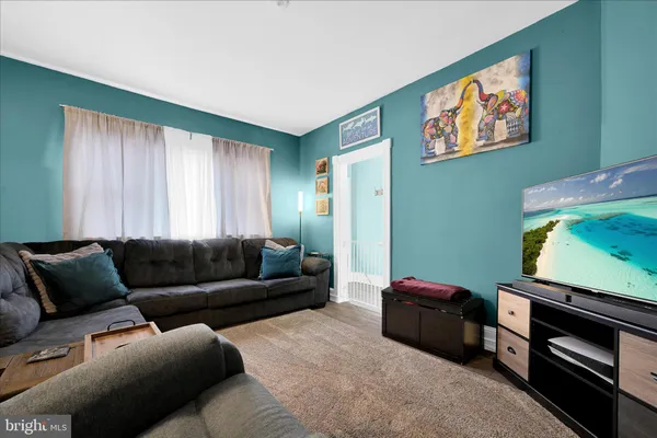 a living room with furniture a window and a flat screen tv