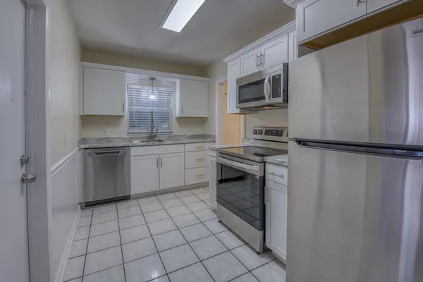 a kitchen with stainless steel appliances granite countertop a refrigerator sink and stove