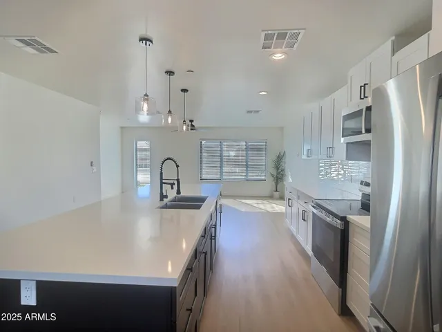 a kitchen with stainless steel appliances granite countertop a sink stove and refrigerator
