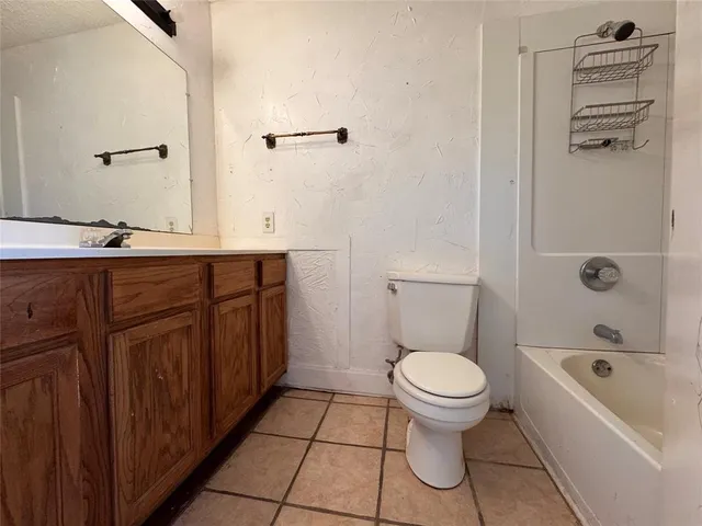 a bathroom with a granite countertop toilet a sink and bathtub