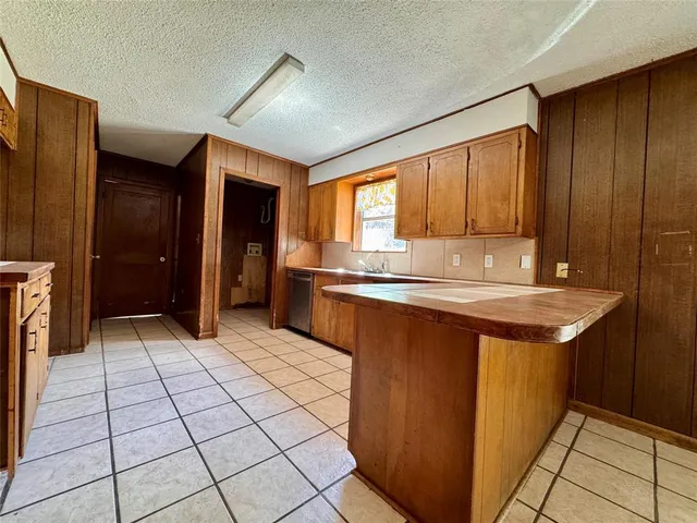 a kitchen with granite countertop a sink cabinets and stainless steel appliances