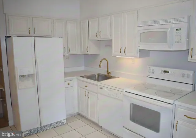 a kitchen with white cabinets and white appliances