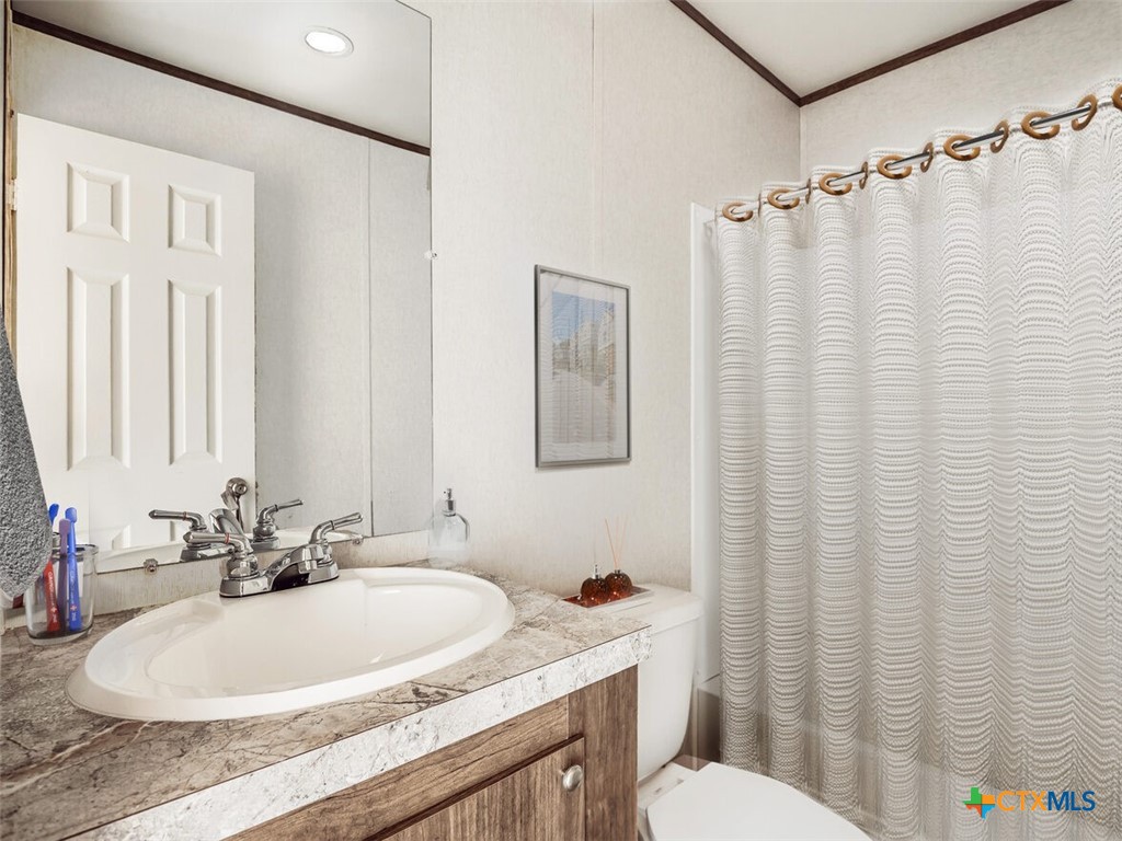 352 Trammel Road Eddy, TX 76524 - Photo 9 of 11 a bathroom with a sink a toilet and shower curtain
