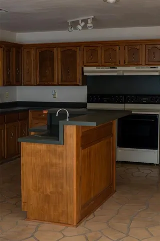 a kitchen with granite countertop a stove and cabinets