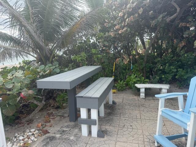 5520 North Ocean Boulevard, Unit 111 Ocean Ridge, FL 33435 - Photo 49 of 63 a view of a patio with table and chairs with wooden fence and plants