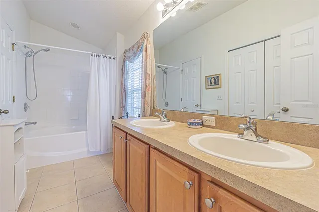 a bathroom with a sink double vanity mirror and a bathtub