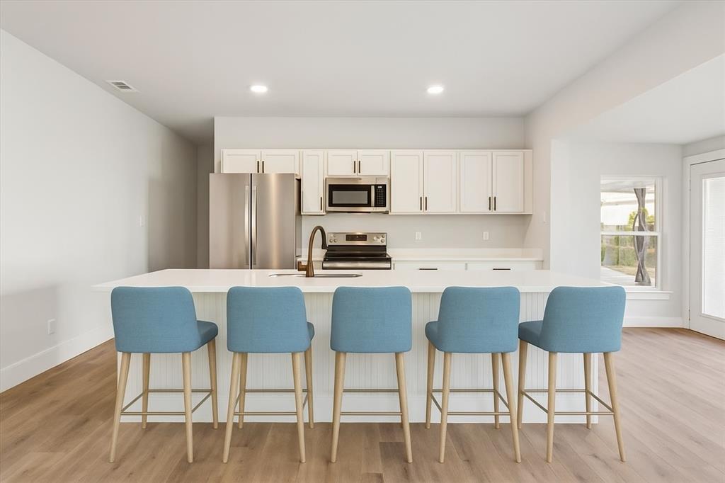 900 North 22nd Street Waco, TX 76707 - Photo 4 of 37 a kitchen with granite countertop a dining table chairs and a refrigerator