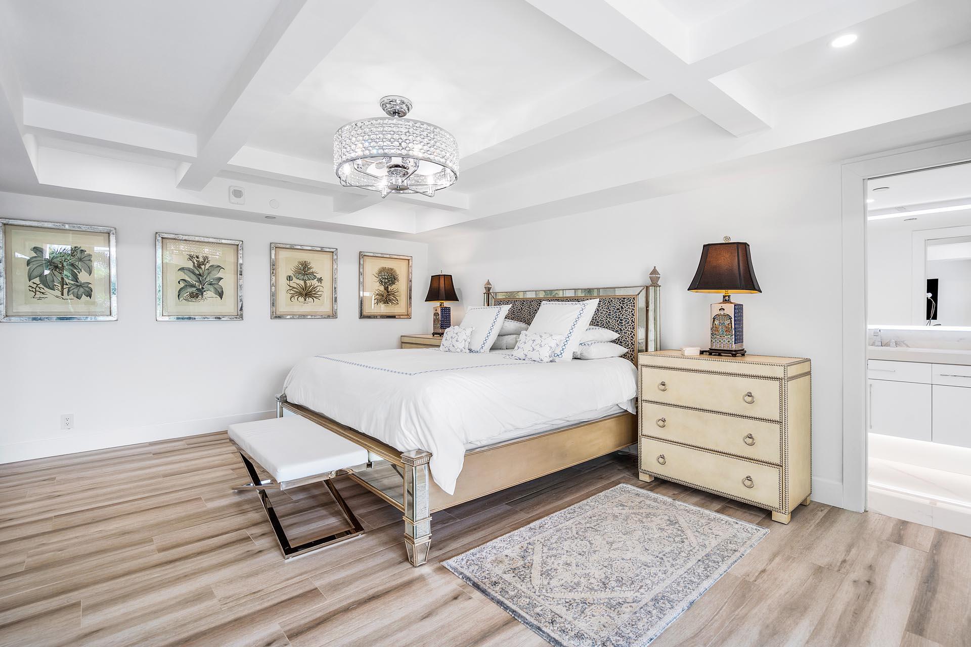 100 Southeast 5th Avenue, Unit 416 Boca Raton, FL 33432 - Photo 16 of 42 a bedroom with a bed and a chandelier