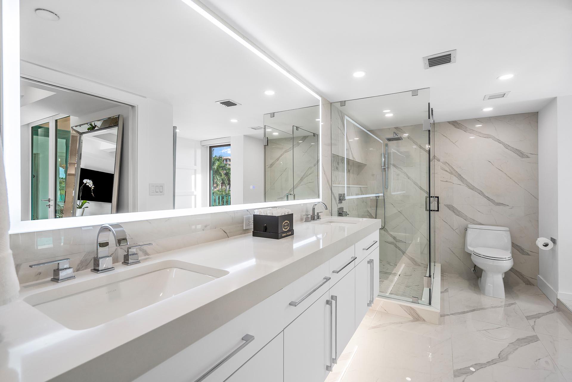 100 Southeast 5th Avenue, Unit 416 Boca Raton, FL 33432 - Photo 17 of 42 a bathroom with a granite countertop sink a toilet and a large mirror