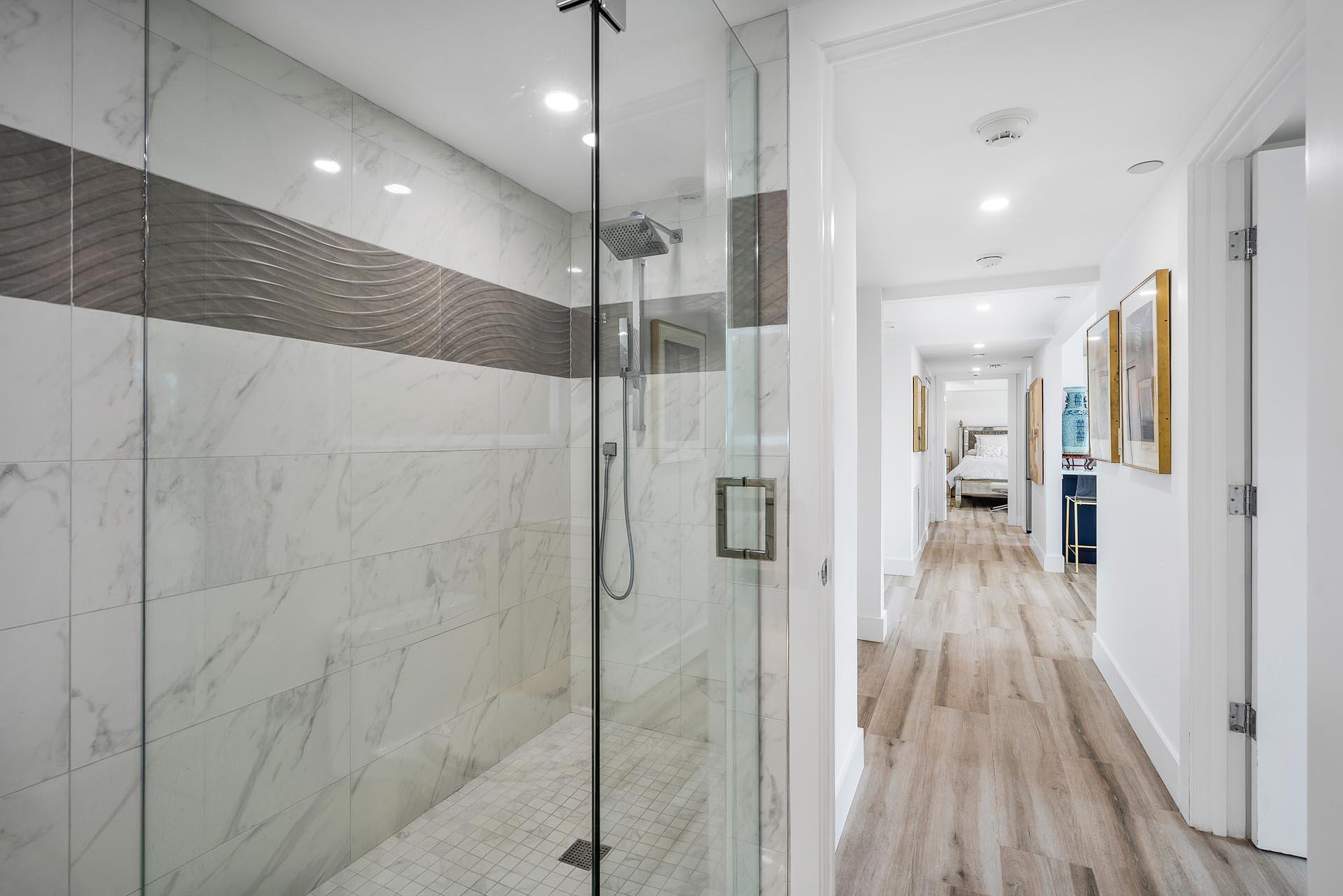 100 Southeast 5th Avenue, Unit 416 Boca Raton, FL 33432 - Photo 26 of 42 a bathroom with a glass shower door and a wooden floor