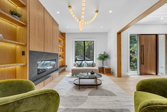 a living room with furniture fireplace and a large window