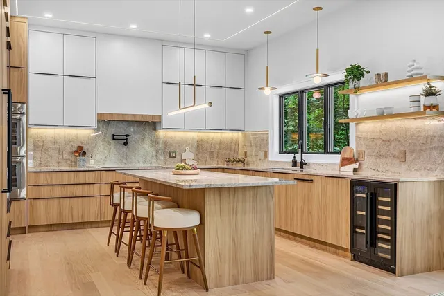 a kitchen with stainless steel appliances granite countertop a table chairs sink and cabinets