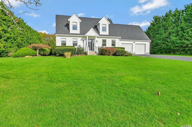 a front view of a house with a yard and trees