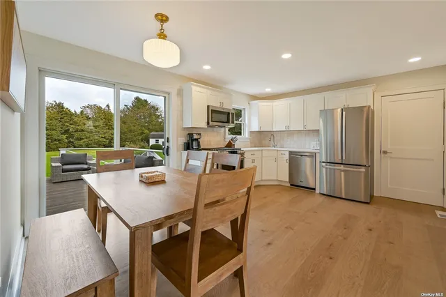 a kitchen with a table chairs refrigerator and microwave