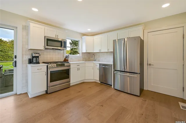 a kitchen with white cabinets and stainless steel appliances