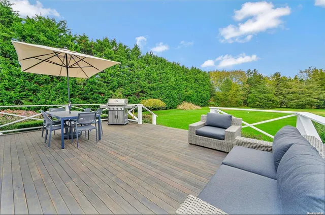 an outdoor sitting area with furniture and garden view