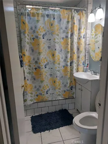 a bathroom with a sink a toilet and shower curtain