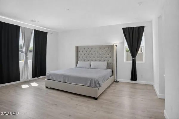 a bedroom with a bed and a painting on the wall