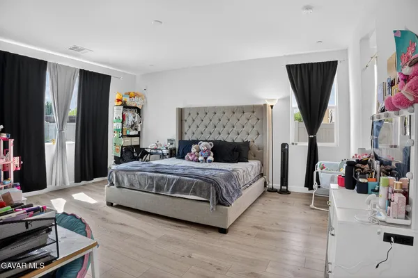 a bedroom with a bed a flat screen tv and dresser