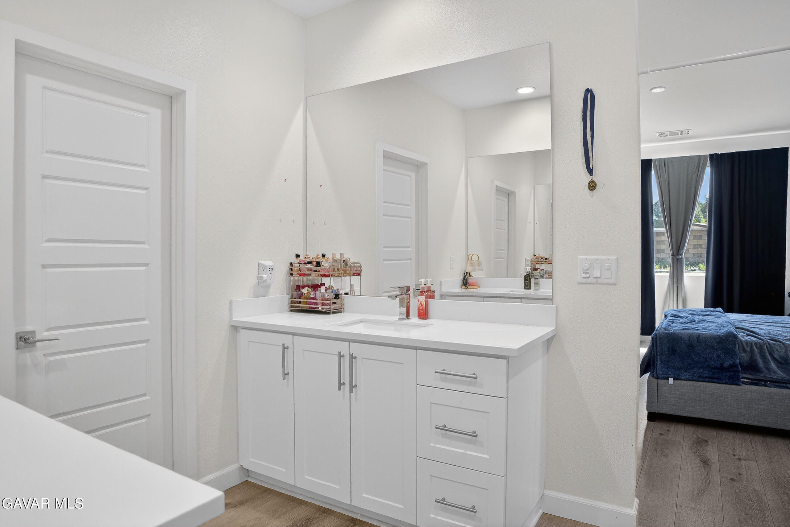 38018 Periwinkle Place Palmdale, CA 93550 - Photo 14 of 32 a en suite bathroom with a sink a mirror and a shower