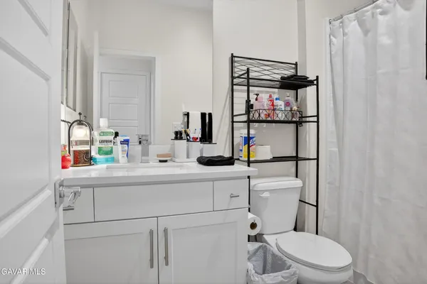 a bathroom with a sink vanity mirror and toilet