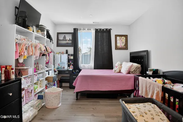 a bedroom with a bed a couch and dresser