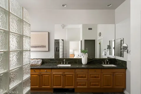 a bathroom with double sink and a mirror