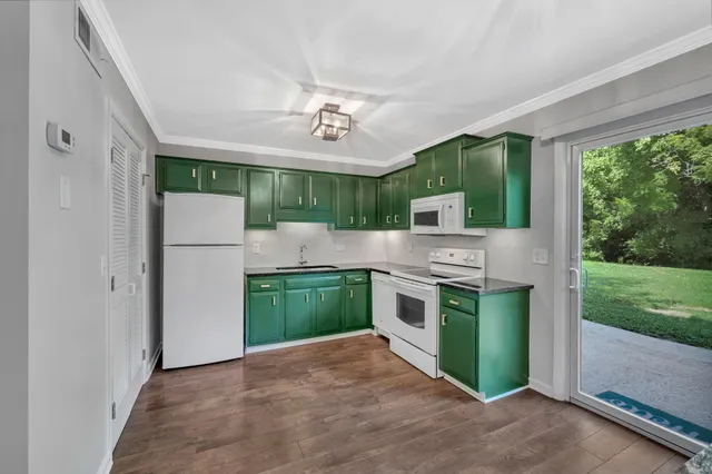 a kitchen with kitchen island a sink stainless steel appliances cabinets and a large window