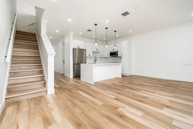 a view of a kitchen with wooden floor and staircase