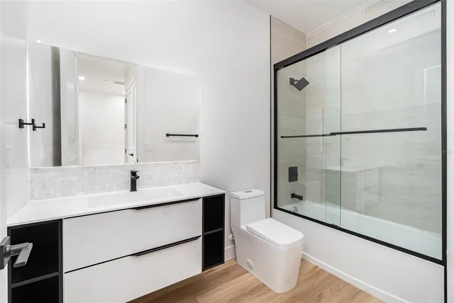 a bathroom with a sink toilet a mirror and shower