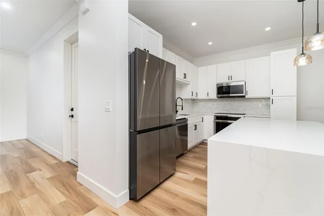 a kitchen with stainless steel appliances a refrigerator sink and microwave