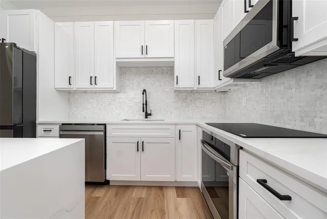 a kitchen with stainless steel appliances granite countertop a sink stove and microwave