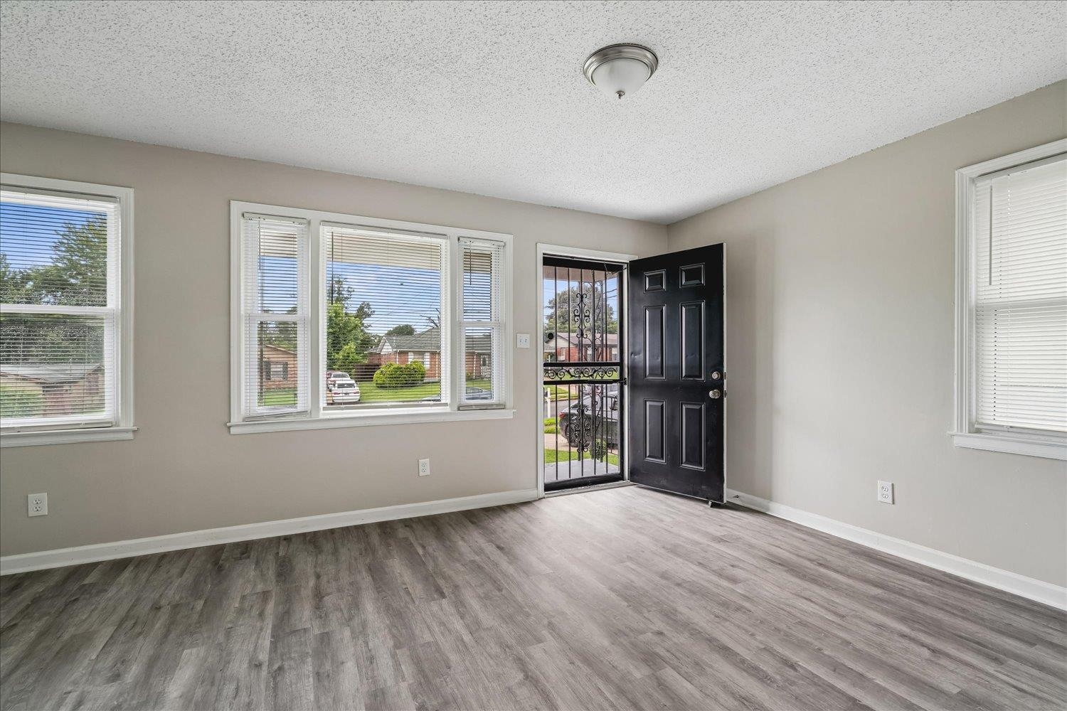 2518 Manchester Road Memphis, TN 38114 - Photo 5 of 23 Open concept room featuring wood-finish flooring, light neutral wall tones, and white trim
