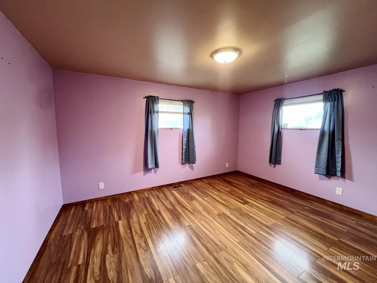 603 Maple Street Nezperce, ID 83543 - Photo 11 of 26 Unfurnished room with wood finished floors and healthy amount of natural light