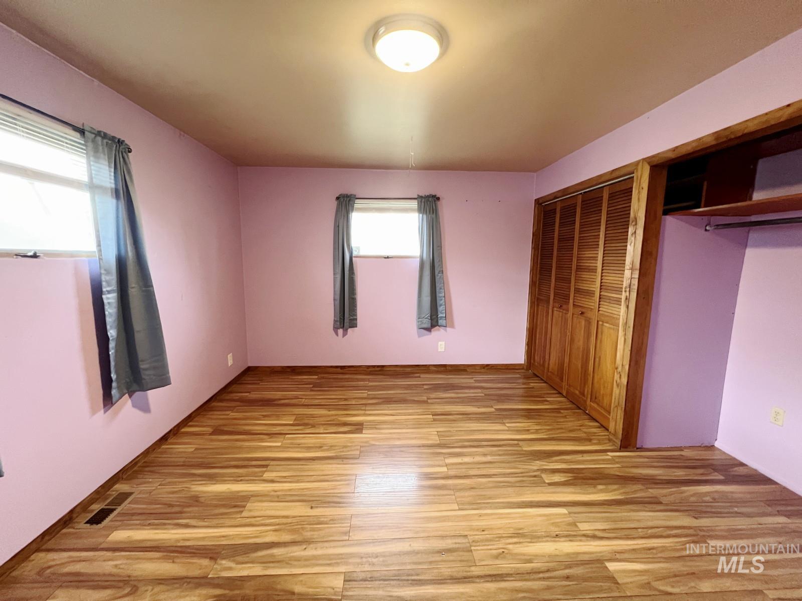 603 Maple Street Nezperce, ID 83543 - Photo 12 of 26 Unfurnished bedroom featuring light wood-type flooring and multiple closets