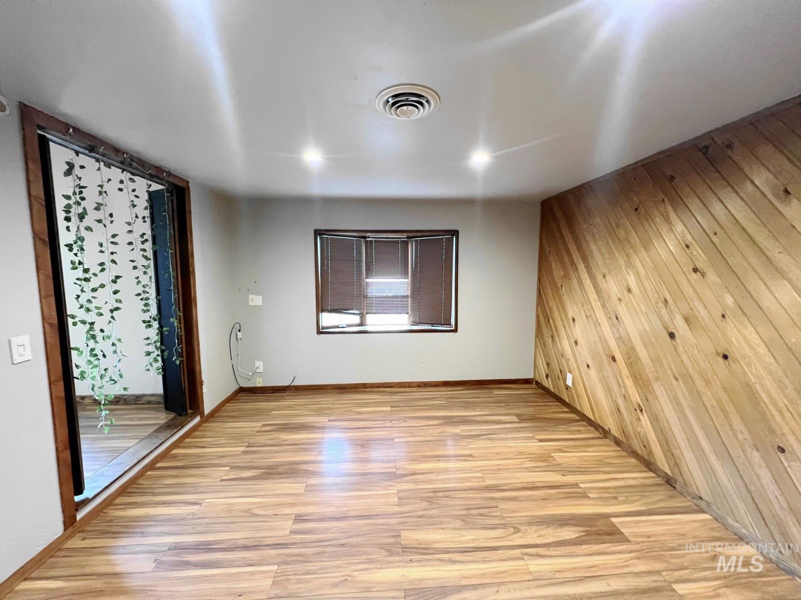 603 Maple Street Nezperce, ID 83543 - Photo 6 of 26 Unfurnished room with wooden walls and light wood-type flooring