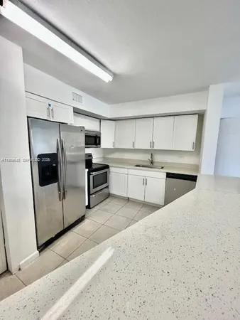 a kitchen with stainless steel appliances a sink a stove a microwave and cabinets
