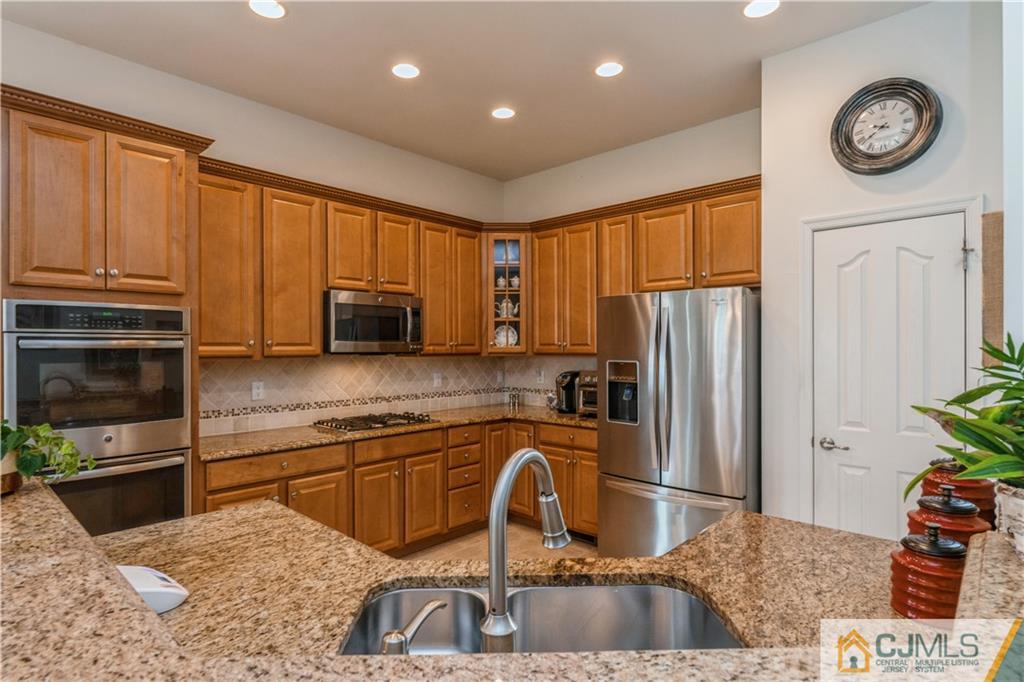 18 Mandrake Road Monroe Township, NJ 08831 - Photo 14 of 44 a kitchen with granite countertop a refrigerator a stove a sink a counter space and cabinets