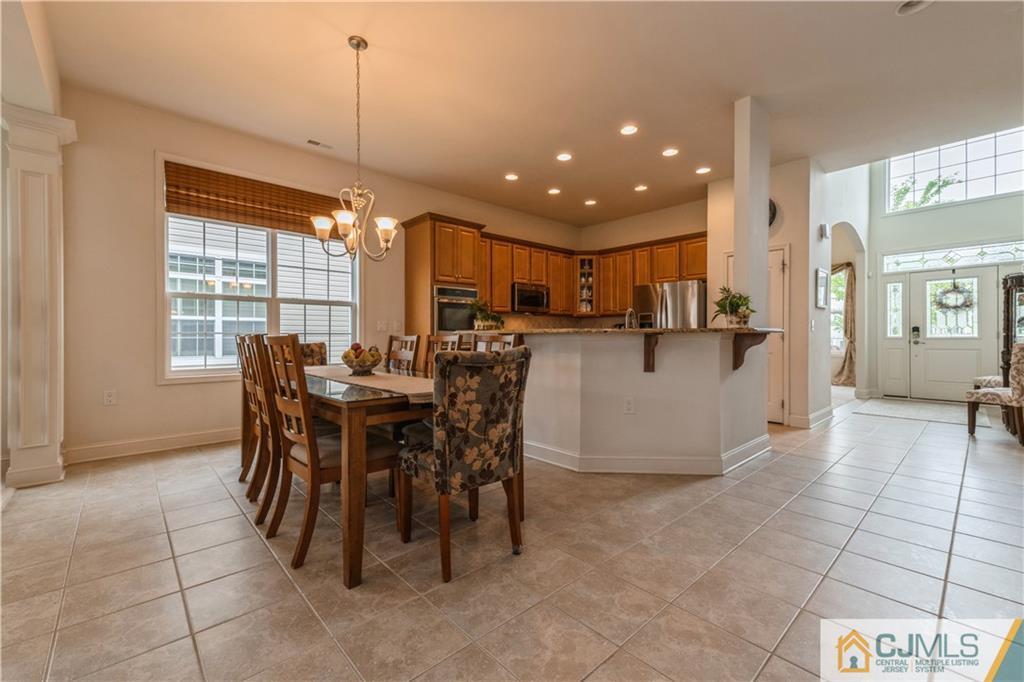 18 Mandrake Road Monroe Township, NJ 08831 - Photo 15 of 44 a view of a dining room and livingroom with furniture a rug a kitchen and a chandelier