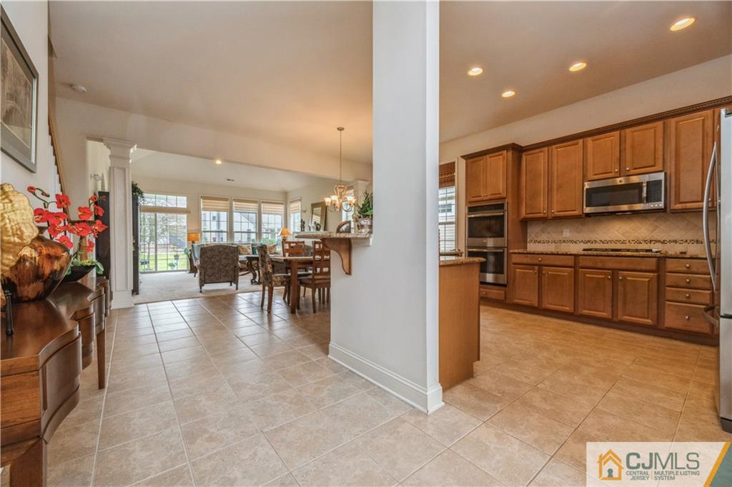 18 Mandrake Road Monroe Township, NJ 08831 - Photo 10 of 44 a kitchen with stainless steel appliances a dining table chairs and a refrigerator